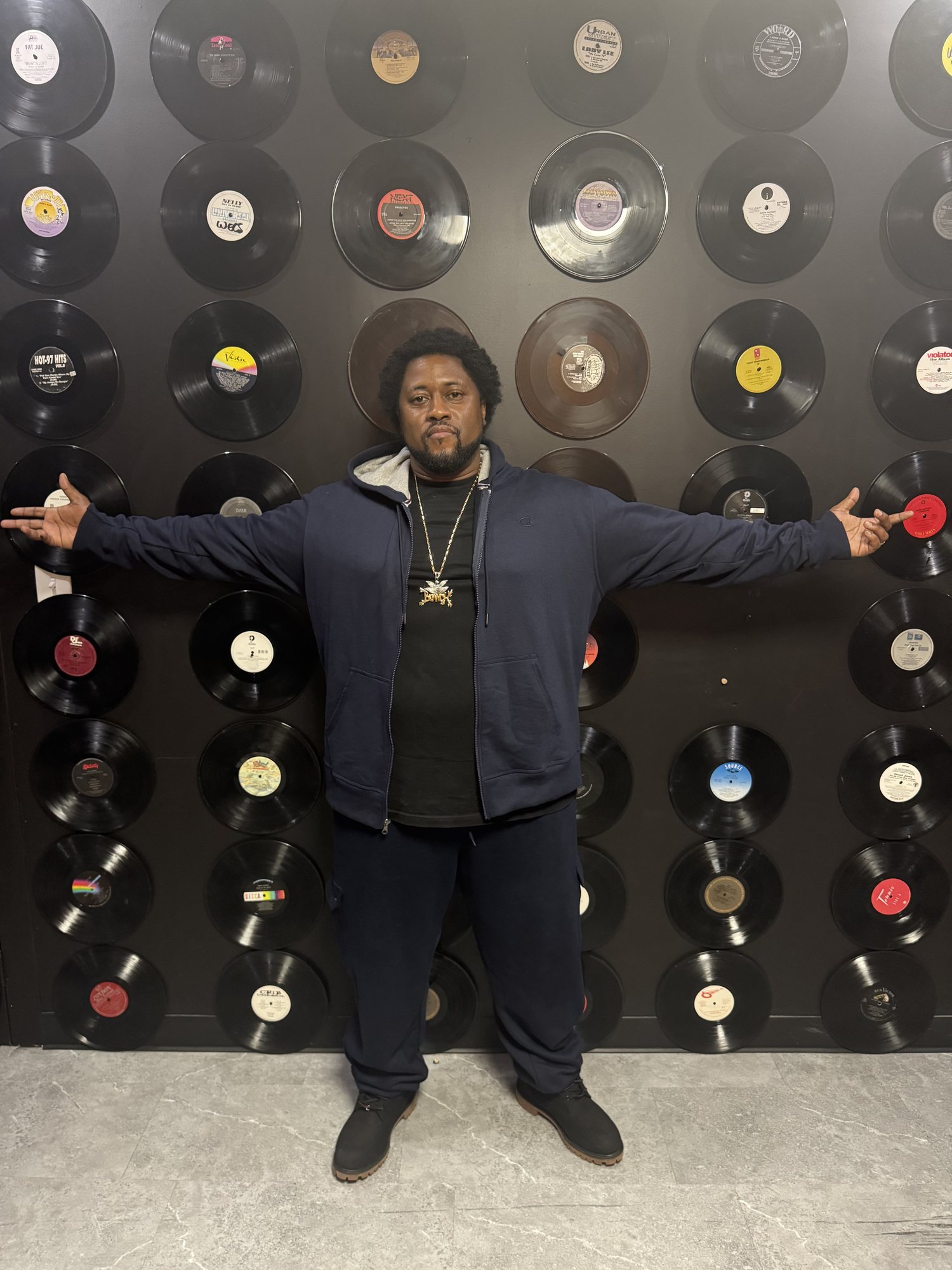 GBranch, arms out in front of a wall of records